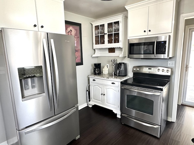 kitchen featuring appliances with stainless steel finishes, glass insert cabinets, dark wood finished floors, and white cabinetry