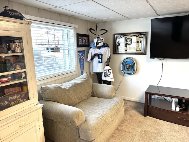 living area featuring a paneled ceiling, baseboards, and carpet flooring