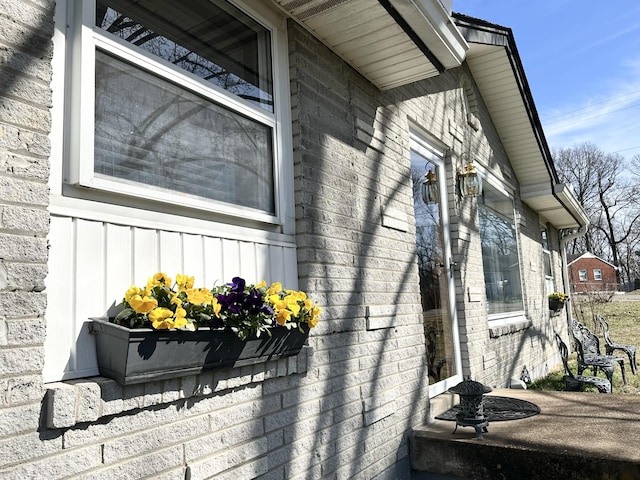 view of property exterior with board and batten siding and brick siding