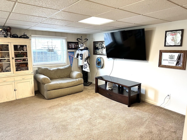 living area with a drop ceiling and carpet flooring