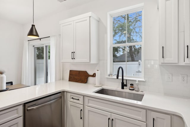 kitchen with white cabinets, dishwasher, backsplash, light countertops, and a sink