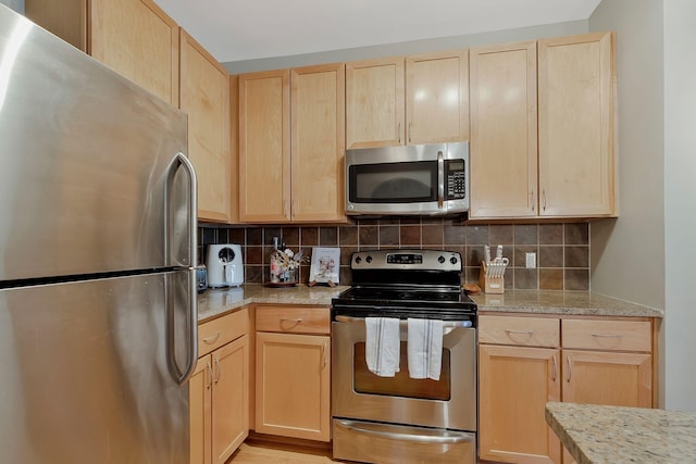 3000 Vanderbilt Pl Unit 323, Nashville, TN 37212 - kitchen with appliances with stainless steel finishes, light brown cabinets, light stone counters, and tasteful backsplash