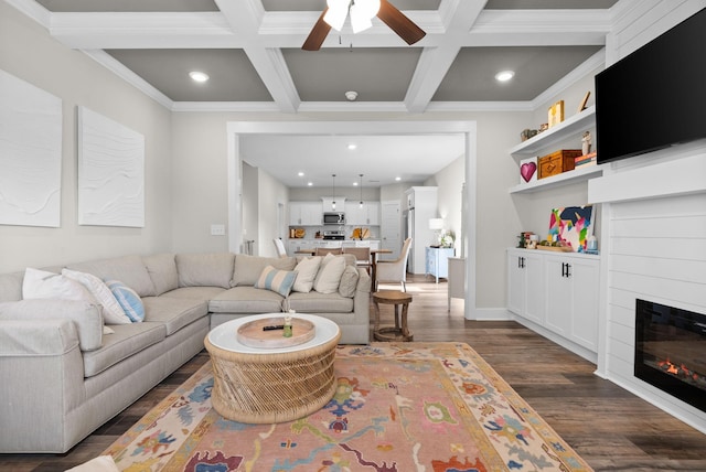 living room with a glass covered fireplace, dark wood-style flooring, coffered ceiling, and beam ceiling