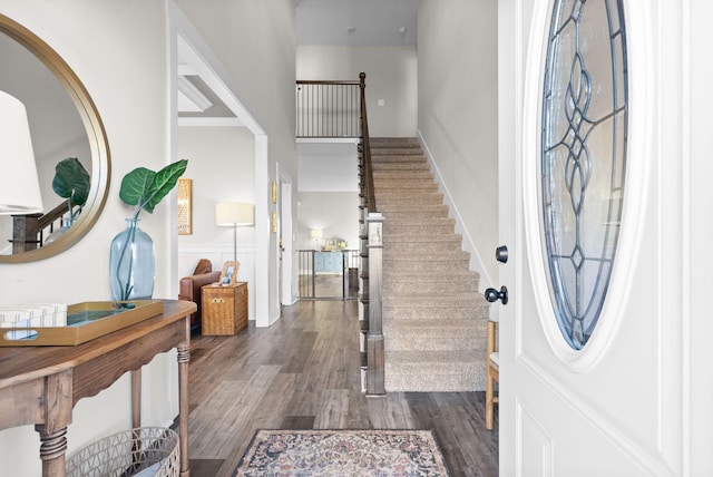 entrance foyer featuring stairway and dark wood-type flooring