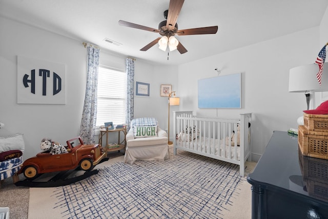 carpeted bedroom featuring visible vents and a ceiling fan