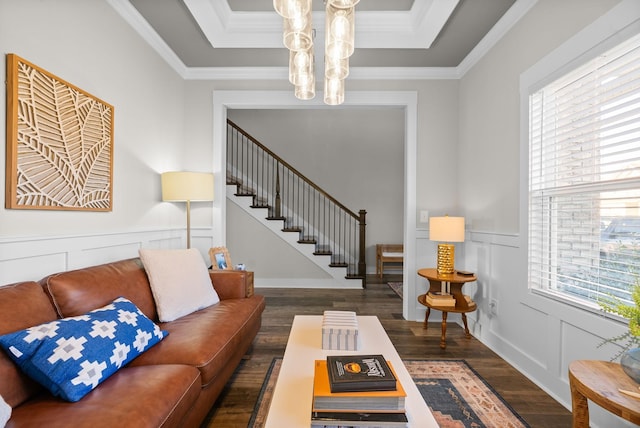 living room featuring crown molding, a decorative wall, stairway, and wood finished floors