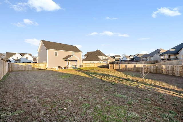 view of yard featuring a fenced backyard and a residential view