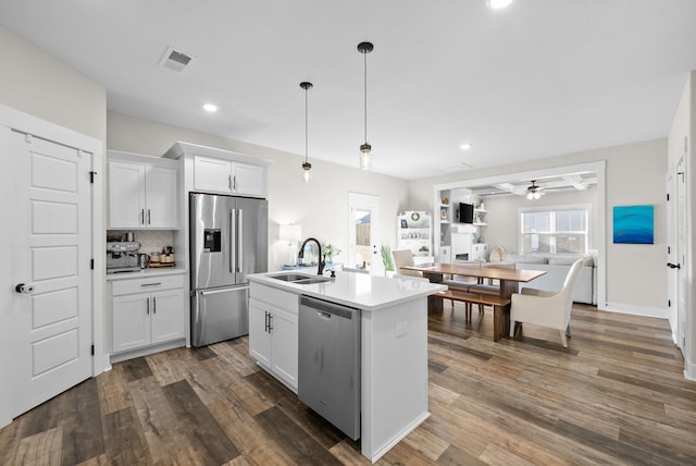 kitchen with dark wood finished floors, visible vents, stainless steel appliances, and a sink