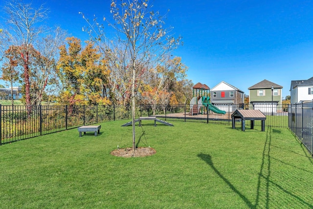 view of home's community with a yard, playground community, and fence