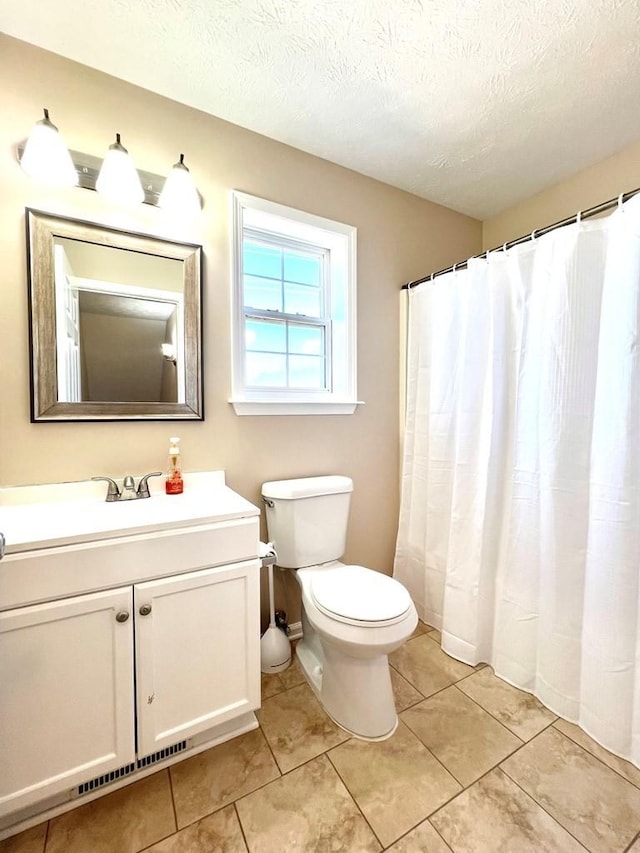 full bathroom featuring a textured ceiling, tile patterned flooring, vanity, and toilet