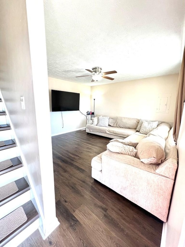 living area featuring ceiling fan, a textured ceiling, and wood finished floors