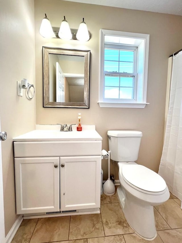 bathroom featuring tile patterned flooring, baseboards, vanity, and toilet