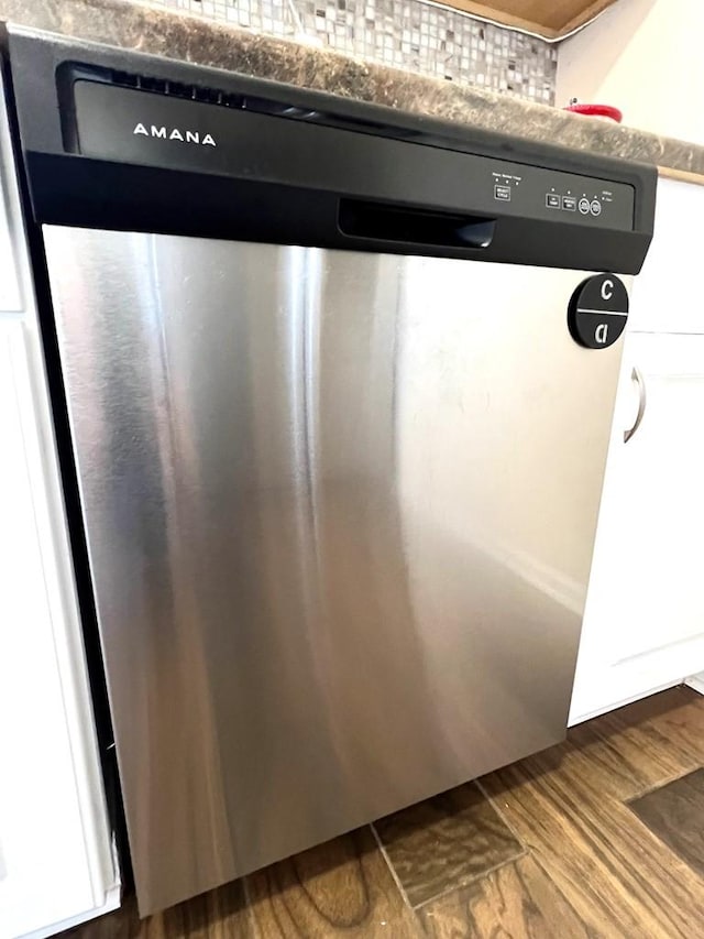 interior details with dark wood-style flooring and stainless steel dishwasher