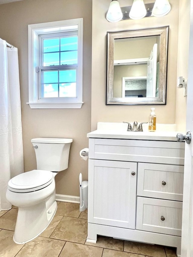 full bath with baseboards, vanity, toilet, and tile patterned floors