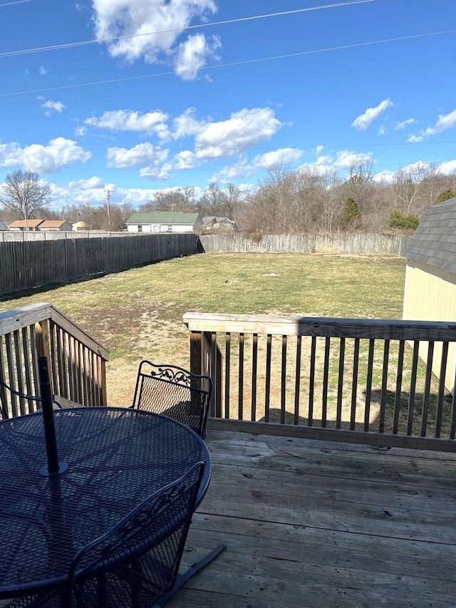 deck featuring outdoor dining area, a fenced backyard, and a lawn