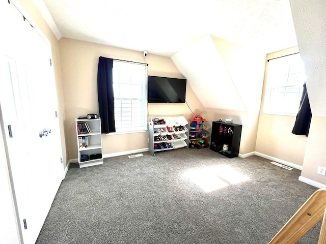 additional living space featuring lofted ceiling, plenty of natural light, visible vents, and baseboards