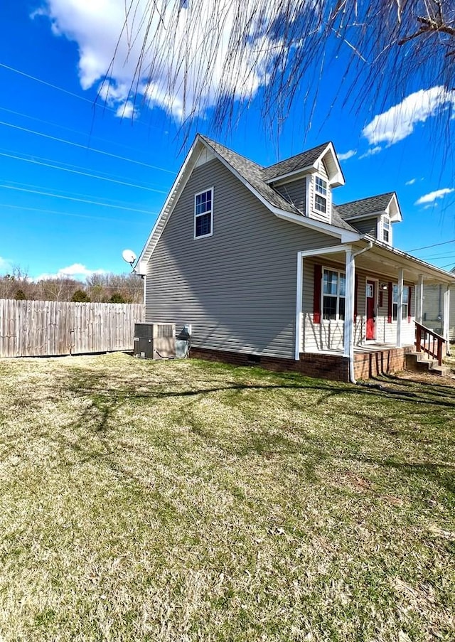 view of side of property featuring a yard, a porch, and fence