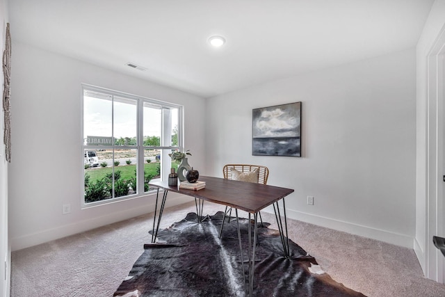 carpeted office featuring visible vents and baseboards