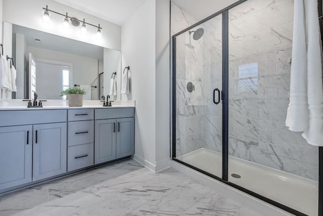 full bathroom featuring double vanity, marble finish floor, a sink, and a stall shower