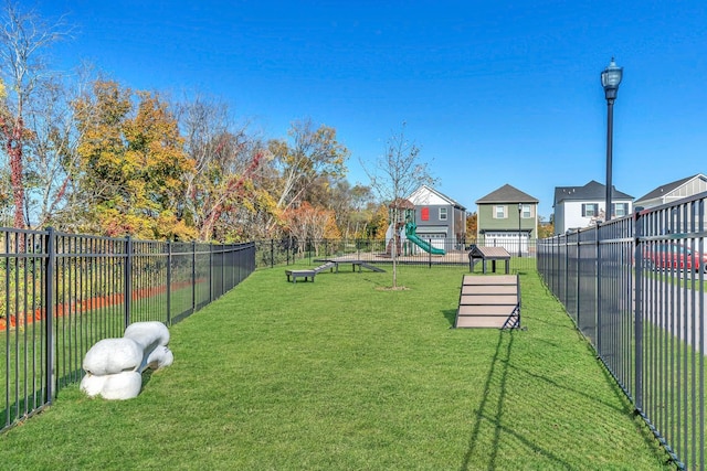 view of home's community with fence and a lawn