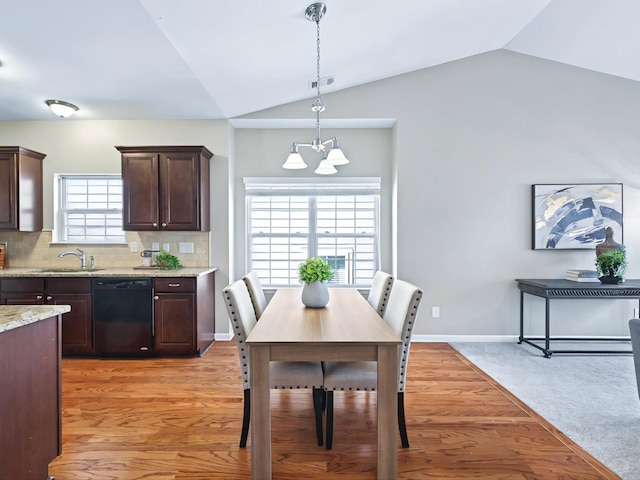 dining area with light wood-style floors, baseboards, a chandelier, and vaulted ceiling