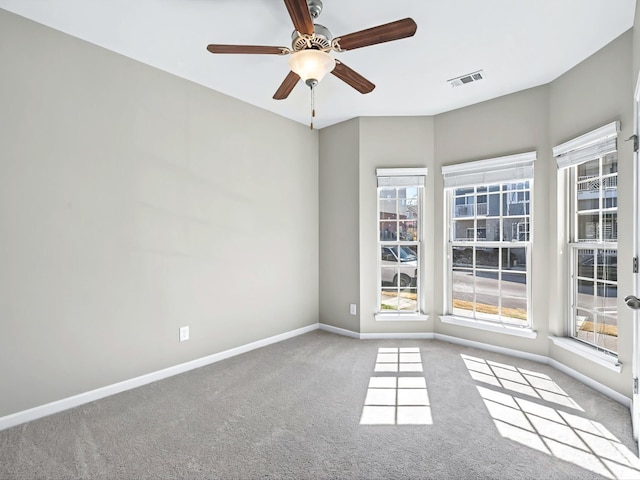 spare room featuring a ceiling fan, carpet flooring, visible vents, and baseboards