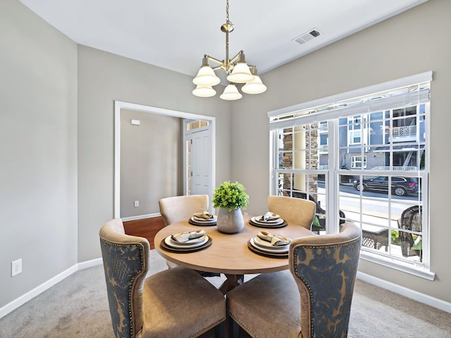 dining room with carpet, baseboards, visible vents, and a chandelier
