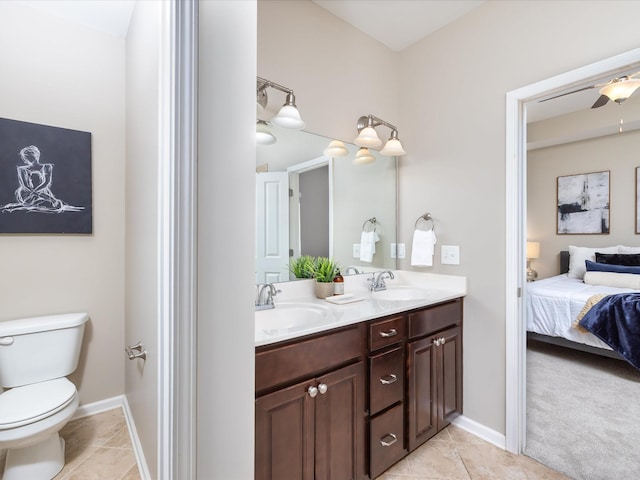 ensuite bathroom featuring toilet, ensuite bath, tile patterned flooring, and a sink