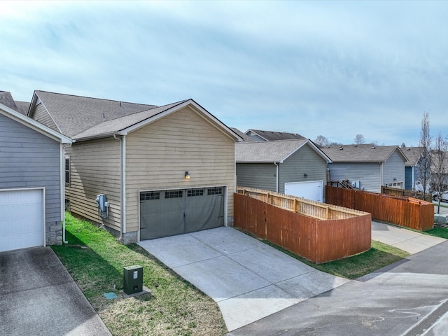 view of front of property featuring concrete driveway and fence