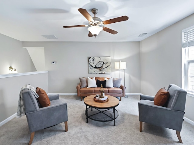 living area featuring light carpet, ceiling fan, visible vents, and baseboards