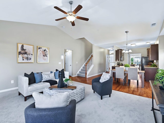 living room featuring lofted ceiling, visible vents, baseboards, and stairs