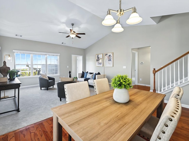 dining room featuring visible vents, lofted ceiling, ceiling fan, stairway, and wood finished floors