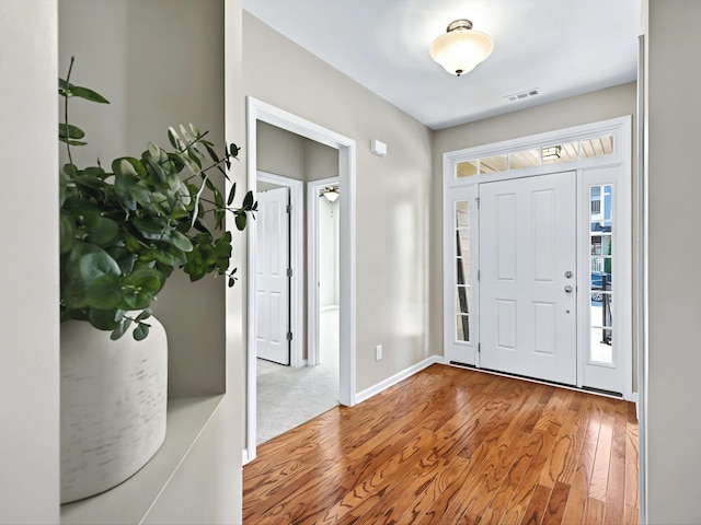 entrance foyer with wood-type flooring, visible vents, and a wealth of natural light