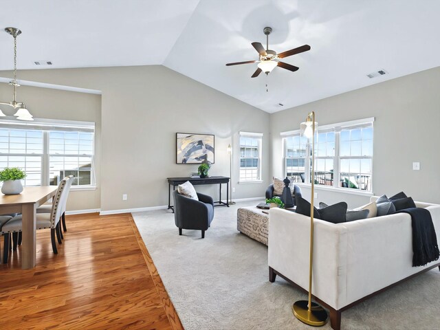 living room featuring lofted ceiling, visible vents, ceiling fan, and baseboards