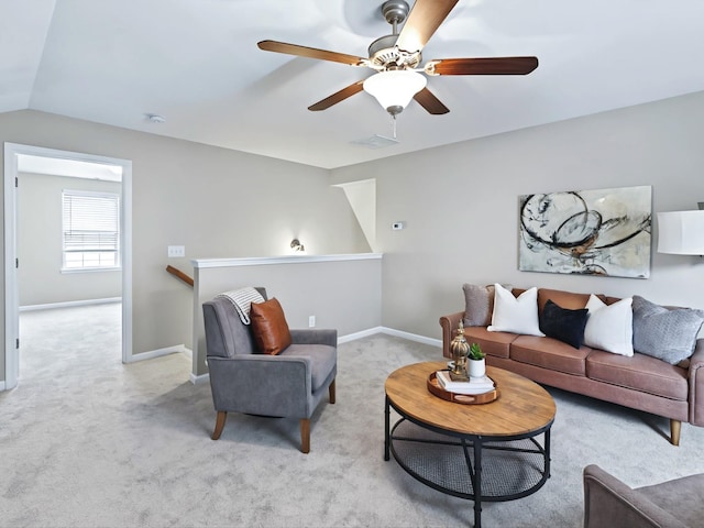 carpeted living room with lofted ceiling, visible vents, and baseboards