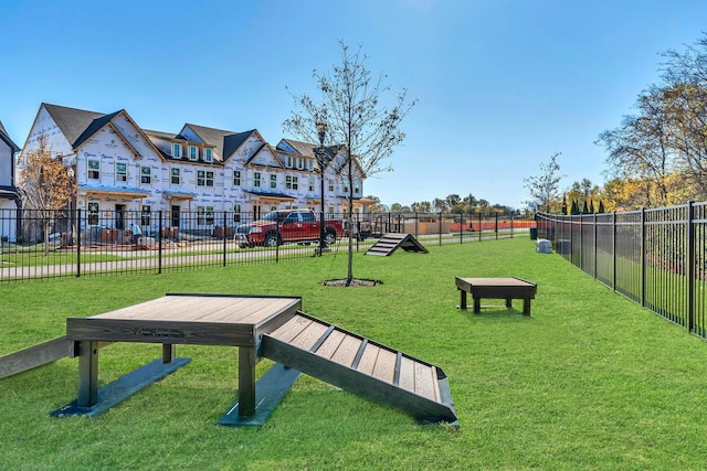 view of property's community with fence and a lawn