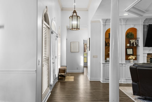 entryway with ornamental molding, dark wood finished floors, and a wealth of natural light