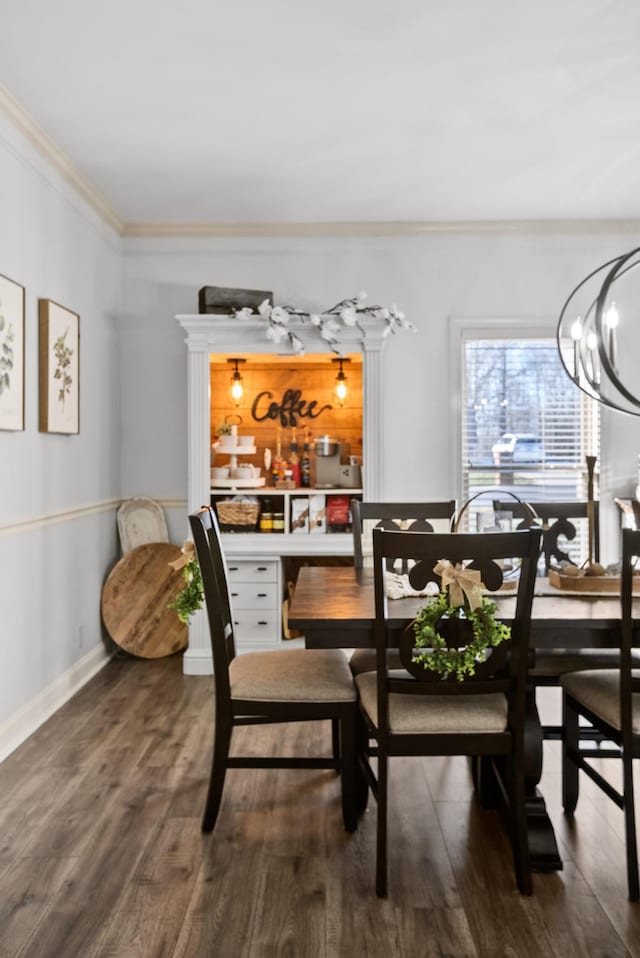 dining space with dark wood-type flooring, crown molding, baseboards, and an inviting chandelier