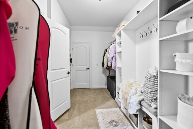 walk in closet featuring light carpet