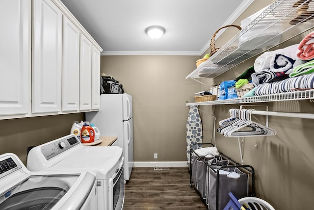 washroom with baseboards, washer and dryer, cabinet space, dark wood finished floors, and crown molding