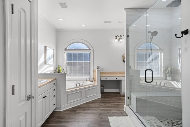 full bath featuring a shower stall, ornamental molding, wood finished floors, and vanity