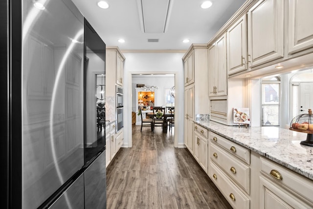 kitchen featuring visible vents, appliances with stainless steel finishes, light stone counters, dark wood-type flooring, and recessed lighting