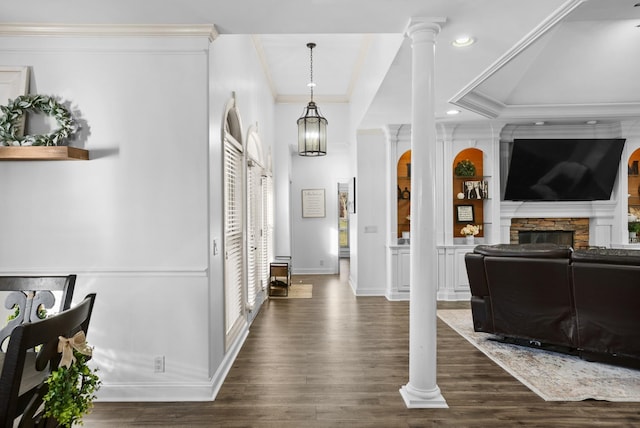 foyer with crown molding, dark wood finished floors, a fireplace, decorative columns, and baseboards