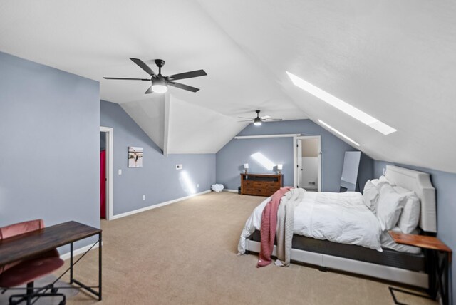 bedroom featuring ceiling fan, vaulted ceiling with skylight, carpet, and baseboards