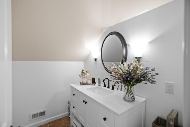 bathroom featuring lofted ceiling, visible vents, and vanity