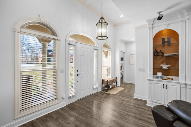 foyer entrance featuring high vaulted ceiling, recessed lighting, dark wood-type flooring, baseboards, and ornamental molding