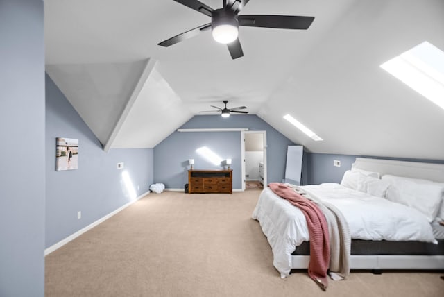 carpeted bedroom with vaulted ceiling with skylight, ceiling fan, and baseboards