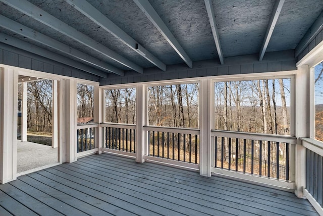 unfurnished sunroom with beam ceiling and plenty of natural light