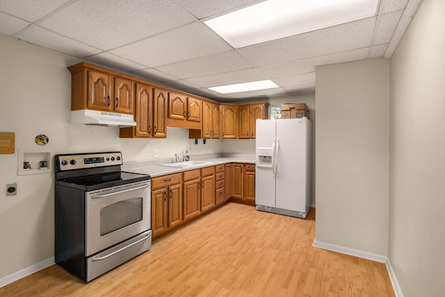 kitchen featuring light wood finished floors, electric stove, under cabinet range hood, white fridge with ice dispenser, and a sink