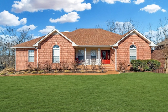 ranch-style house featuring brick siding, a front yard, and a shingled roof